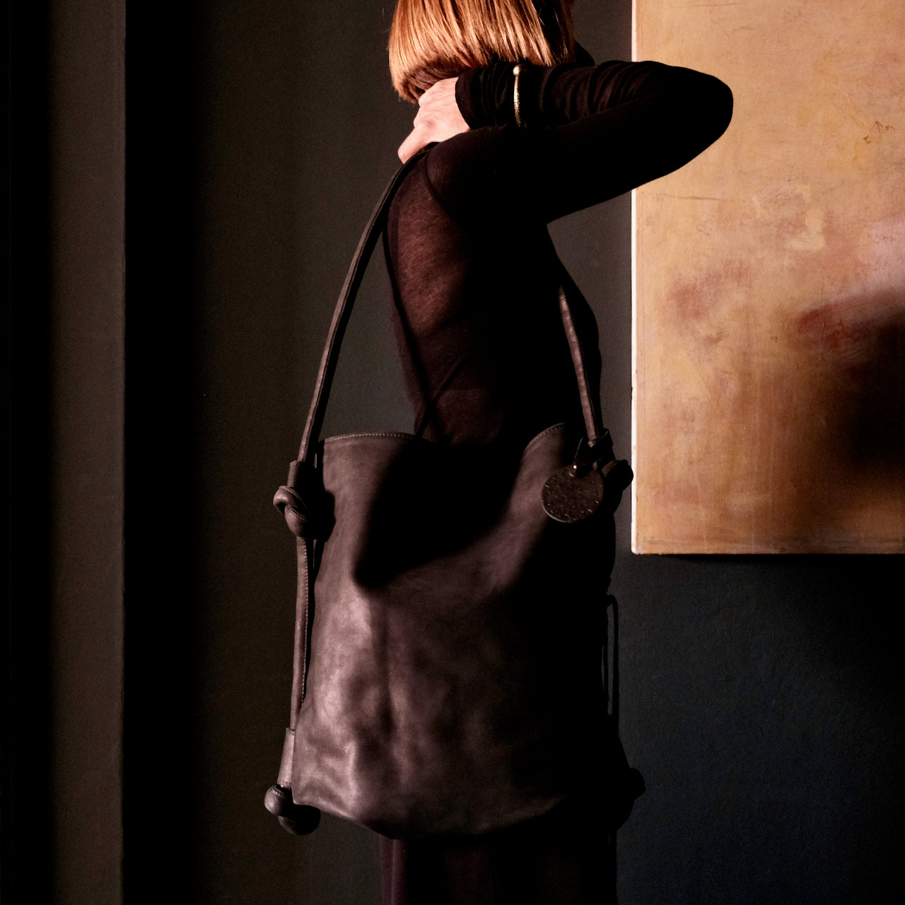 model wearing black leather hayat backpack as shoulder bag