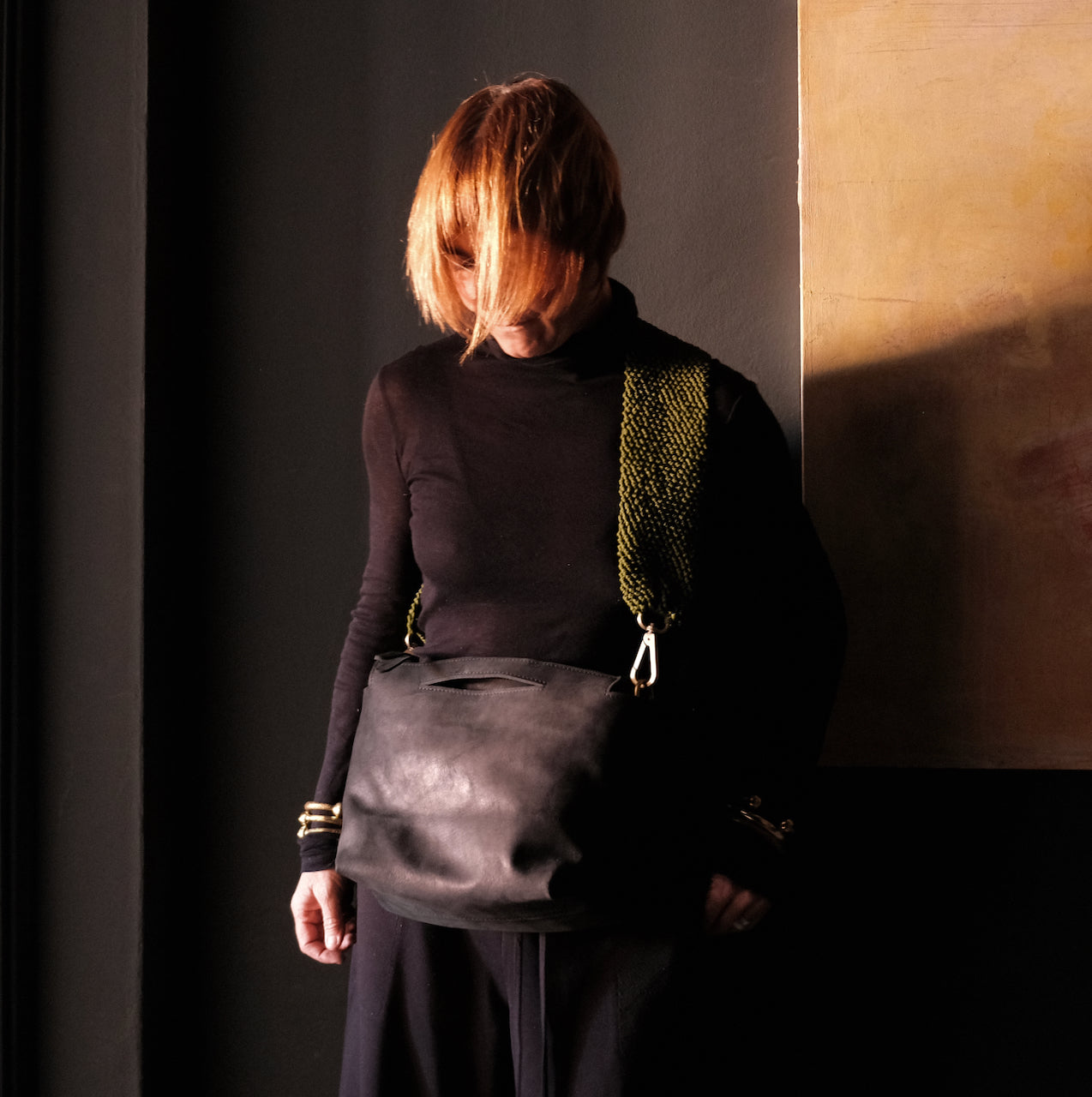 model wearing black leather ogda shoulder bag